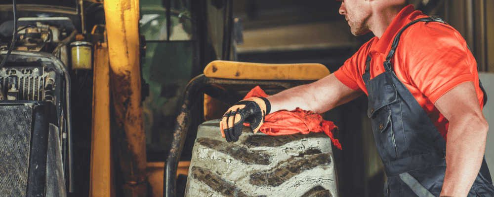 Auf diesem Bild ist eine Person zu sehen, die eine Ausbildung zum/r Land- und Baumaschinenmechatroniker/in absolviert. Dieser Beruf ist sehr vielseitig und umfasst sowohl mechanische als auch elektronische Arbeiten. Die Person auf dem Bild ist damit beschäftigt, eine Baumaschine zu warten und zu reparieren.