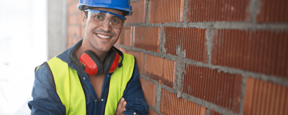 Auf diesem Bild ist eine Person zu sehen, die eine Ausbildung zum/r Maurer/in absolviert. Dieser Beruf ist sehr anstrengend und erfordert viel Kraft und Ausdauer. Die Person auf dem Bild sieht jedoch sehr zufrieden aus mit dem, was sie tut.