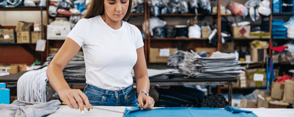 Auf diesem Bild ist eine Person zu sehen, die eine Ausbildung zum/r Textillaboranten/in absolviert. Dieser Beruf umfasst die Herstellung und Prüfung von textilen Produkten aller Art. Die Person auf dem Bild ist damit beschäftigt, ein Kleidungsstück zu prüfen und sorgfältig zu untersuchen.
