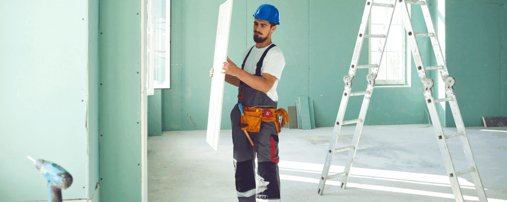 Auf dem Bild ist eine Person zu sehen, die eine Ausbildung zum/r Trockenbaumonteur/in absolviert. Dieser Beruf ist sehr wichtig, da er dafür sorgt, dass Gebäude trocken bleiben.