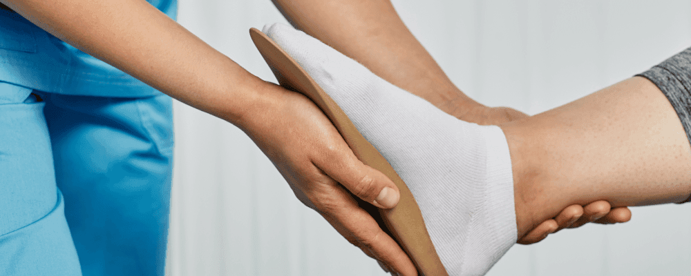 Auf diesem Bild ist eine Person zu sehen, die eine Ausbildung zum/r Orthopädieschuhmacher/in absolviert. Dieser Beruf ist sehr wichtig, da er Menschen dabei hilft, ihre Füße richtig zu behandeln und so Schmerzen zu lindern.