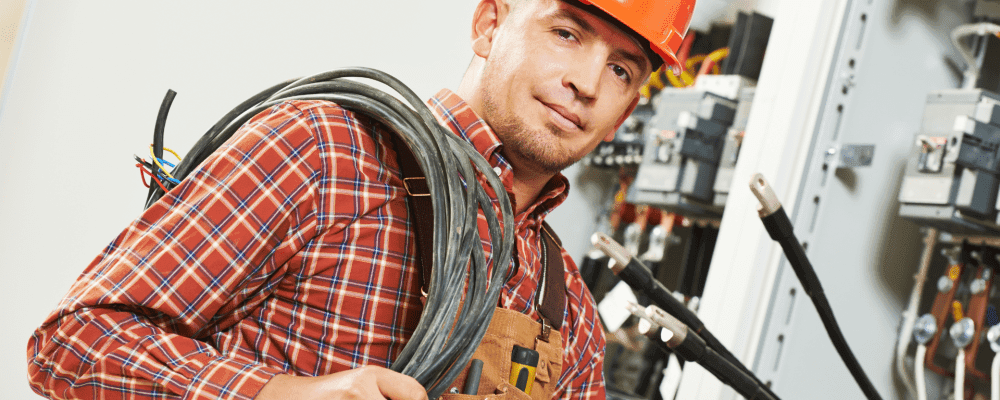 Auf diesem Bild ist eine Person zu sehen, die eine Ausbildung zum/r Elektroniker/in für Betriebstechnik absolviert. Dieser Beruf umfasst die Installation, Wartung und Reparatur von elektrischen Anlagen und Geräten.