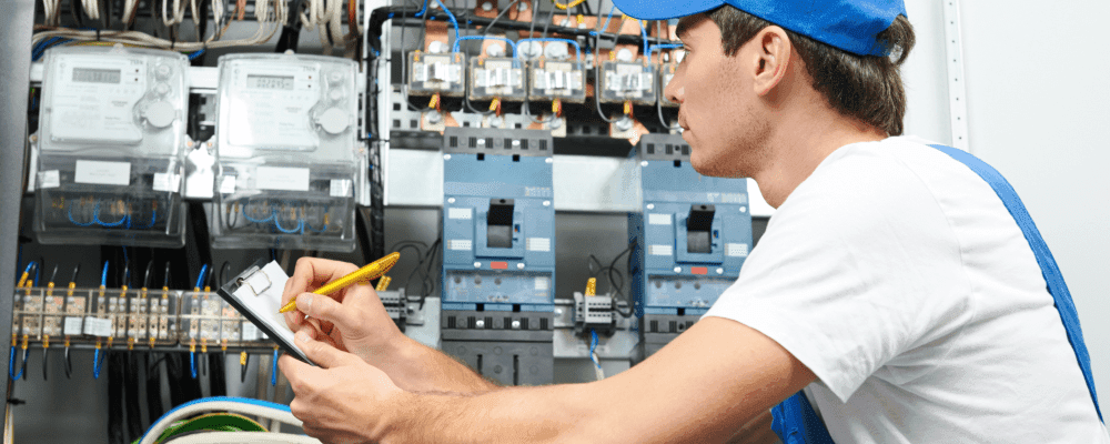 Auf diesem Bild ist eine Person zu sehen, die eine Ausbildung zum/r Elektroniker/in für Informations- und Systemtechnik absolviert. Dieser Beruf ist sehr vielseitig und umfasst die Planung, Installation und Wartung von elektronischen Komponenten und Systemen. Die Person auf dem Bild ist damit beschäftigt, ein solches System zu installieren.