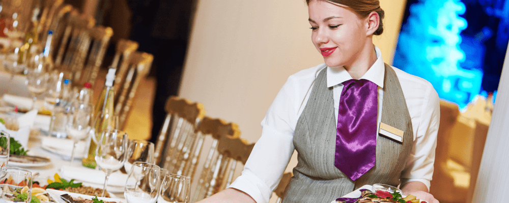 Auf diesem Bild ist eine Person zu sehen, die eine Ausbildung zum/r Fachfrau/-mann für Restaurants- & Veranstaltungsgastronomie absolviert. Dieser Beruf umfasst die Organisation und Durchführung von gastronomischen Veranstaltungen aller Art. Die Fachkraft muss hierbei stets flexibel sein und sich schnell auf veränderte Situationen einstellen können.