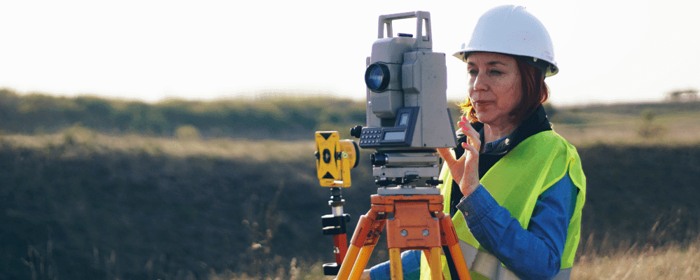 Auf diesem Bild ist eine Person zu sehen, die eine Ausbildung zum/r Vermessungstechniker/in absolviert. Dieser Beruf ist sehr wichtig, da er dafür sorgt, dass Bauprojekte genau geplant und umgesetzt werden können.