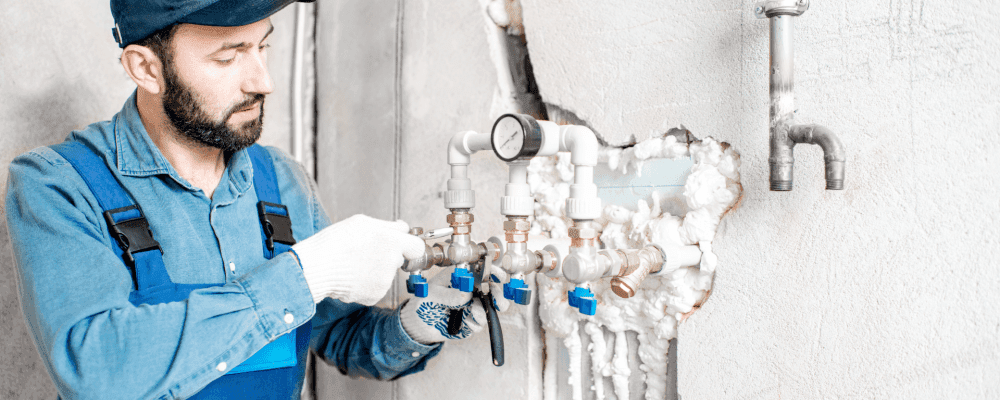 Auf diesem Bild ist eine Person zu sehen, die eine Ausbildung zum/r Wasserbauer/in ausübt. Sie arbeitet mit viel Sorgfalt und Genauigkeit an den Leitungen, um sicherzustellen, dass das Wasser fließt.