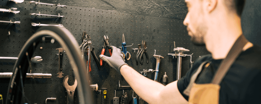 Auf diesem Bild ist eine Person zu sehen, die eine Ausbildung zum/r Fahrradmonteur/in absolviert. Dieser Beruf ist sehr vielseitig und umfasst sowohl das Reparieren von Fahrrädern als auch das Aufbauen neuer Räder. 