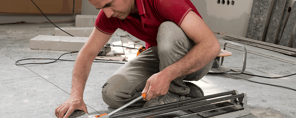 Auf diesem Bild ist eine Person zu sehen, die eine Ausbildung zum/r Fliesenleger/in absolviert. Sie arbeitet sorgfältig und genau, um perfekte Ergebnisse zu erzielen.