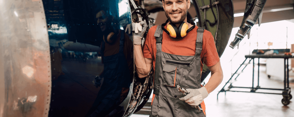 Auf diesem Bild ist eine Person zu sehen, die eine Ausbildung zum/r Fluggerätmechaniker/in absolviert. Dieser Beruf umfasst die Wartung und Reparatur von Flugzeugen und anderen Luftfahrzeugen. 