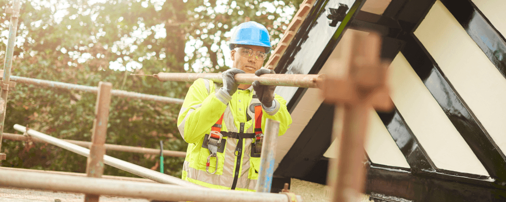 Auf diesem Bild ist eine Person zu sehen, die eine Ausbildung zum/r Gerüstbauer/in absolviert. Gerüstbauer sind für die Errichtung und Demontage von Gerüsten aller Art zuständig. Sie arbeiten sowohl an Neubauten als auch an der Sanierung oder dem Umbau von bestehenden Gebäuden.