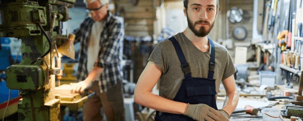 Auf diesem Bild ist eine Person zu sehen, die eine Ausbildung zum/r Holzbearbeitungsmechaniker/in absolviert. Dieser Beruf ist sehr vielseitig und umfasst die Herstellung sowie Reparatur von verschiedenen Holzprodukten. Die Person auf dem Bild sieht daher mit Sicherheit sehr viel Können und Geschicklichkeit aus.