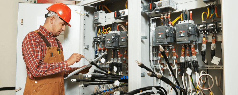 Auf diesem Bild ist eine Person zu sehen, die ein duales Studium Energie- und Gebäudetechnik absolviert. Dieser Beruf umfasst die Planung, Installation und Wartung von technischen Anlagen in Gebäuden. Die Person auf dem Bild ist damit beschäftigt, eine solche Anlage zu installieren.