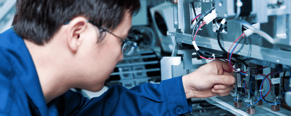 Dieses Bild zeigt eine Person, die ein duales Studium Industrielektronik absolviert. Sie ist damit beschäftigt, elektrische und elektronische Systeme zu entwickeln und zu installieren. Dabei setzt sie ihr umfangreiches Wissen in den Bereichen Physik, Mathematik und Informatik ein.