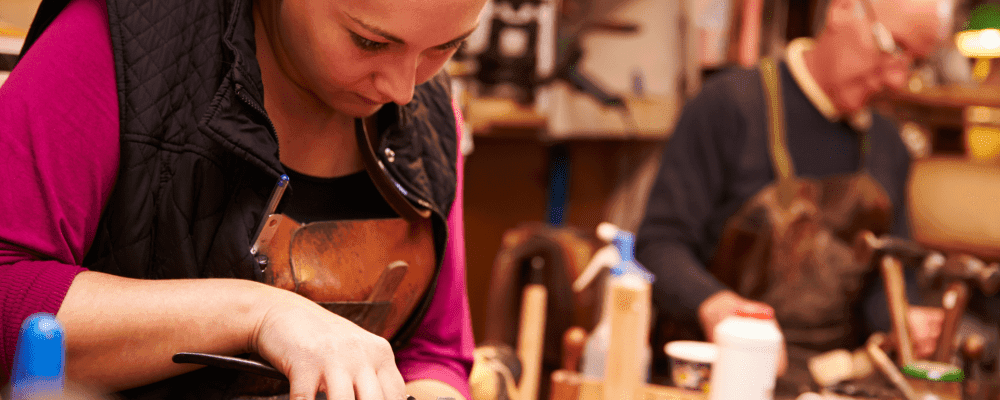Dies ist ein Bild von einer Person, die eine Ausbildung zum Schuhfertiger/in absolviert. Diese Person fertigt Schuhe für Kunden an und sorgt dafür, dass diese passen und bequem sind.